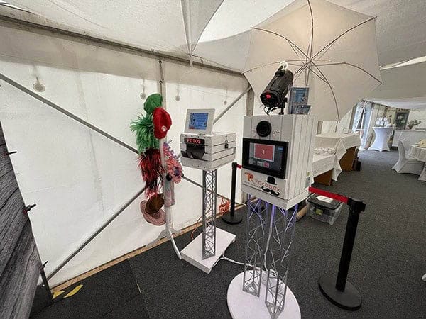 Professionelle Fotobox mit Drucker und Requisiten im Hochzeitszelt aufgebaut.