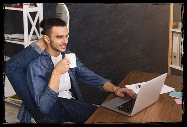 Flexibel und digital: So arbeitet ein moderner Fotobox Anbieter aus Sachsen Mann arbeitet entspannt mit Laptop und Kaffeetasse – flexibles Arbeiten beim Fotobox Anbieter in Sachsen.
