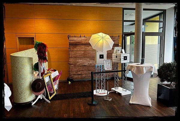 Ein komplettes Fotobox-Setup mit Requisiten, Studioblitz und rustikalem Hintergrund – perfekt vorbereitet für eine Geburtstagsfeier im Hotel Schloss Lichtenwalde. Fotobox für Feier im Hotel Schloss Lichtenwalde mit Hintergrund, Studioblitz und Requisiten