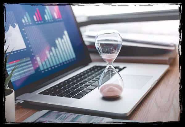 Die Sanduhr auf dem Laptop steht für zeitkritische Probleme – ein typisches Risiko bei der Nutzung einer Versandfotobox, wenn Lieferung oder Aufbau nicht reibungslos funktionieren. Sanduhr auf Laptop symbolisiert Zeitverlust – einer der Nachteile einer Versandfotobox