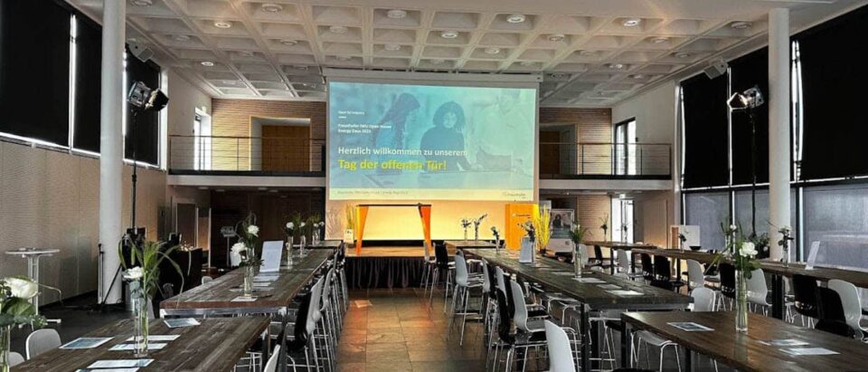 ag der offenen Tür beim Open House / Energy Days am Fraunhofer IWU – stilvoll eingerichteter Veranstaltungsraum mit Bühne und Begrüßungspräsentation.