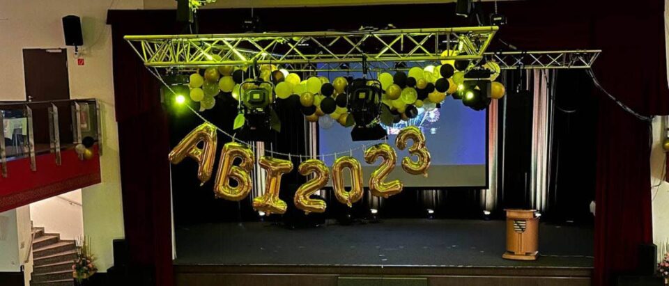 Bühne des Abiballs 2023 mit goldenen Luftballons und stilvoller Dekoration in Schwarz-Gold. Perfekte Kulisse für die Fotobox.