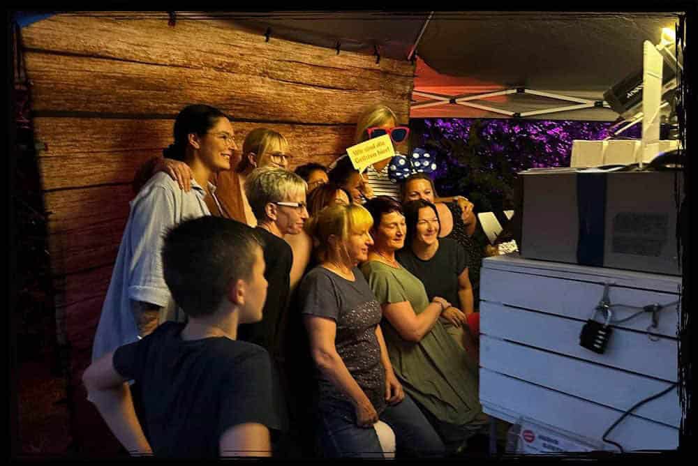 Spaß vor der Fotobox – Sommerfest Chemnitz voller unvergesslicher Momente Eine fröhliche Gruppe posiert gemeinsam vor der Fotobox und hält witzige Schilder und Accessoires in die Kamera.