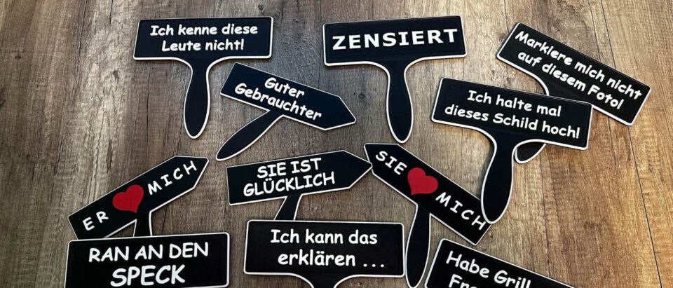 Schwarze 3D-gedruckte Fotobox Schilder mit lustigen Sprüchen auf Holzhintergrund