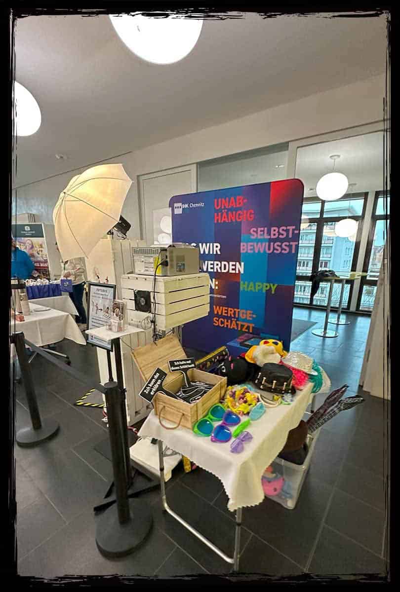 Fotobox-Setup auf der IHK Chemnitz Messe mit Accessoires-Tisch und Hintergrundwand.
