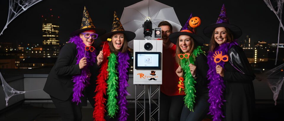 Gruppe feiert Halloween mit Fotobox in Chemnitz, verkleidet mit Hexenhüten und bunten Accessoires.