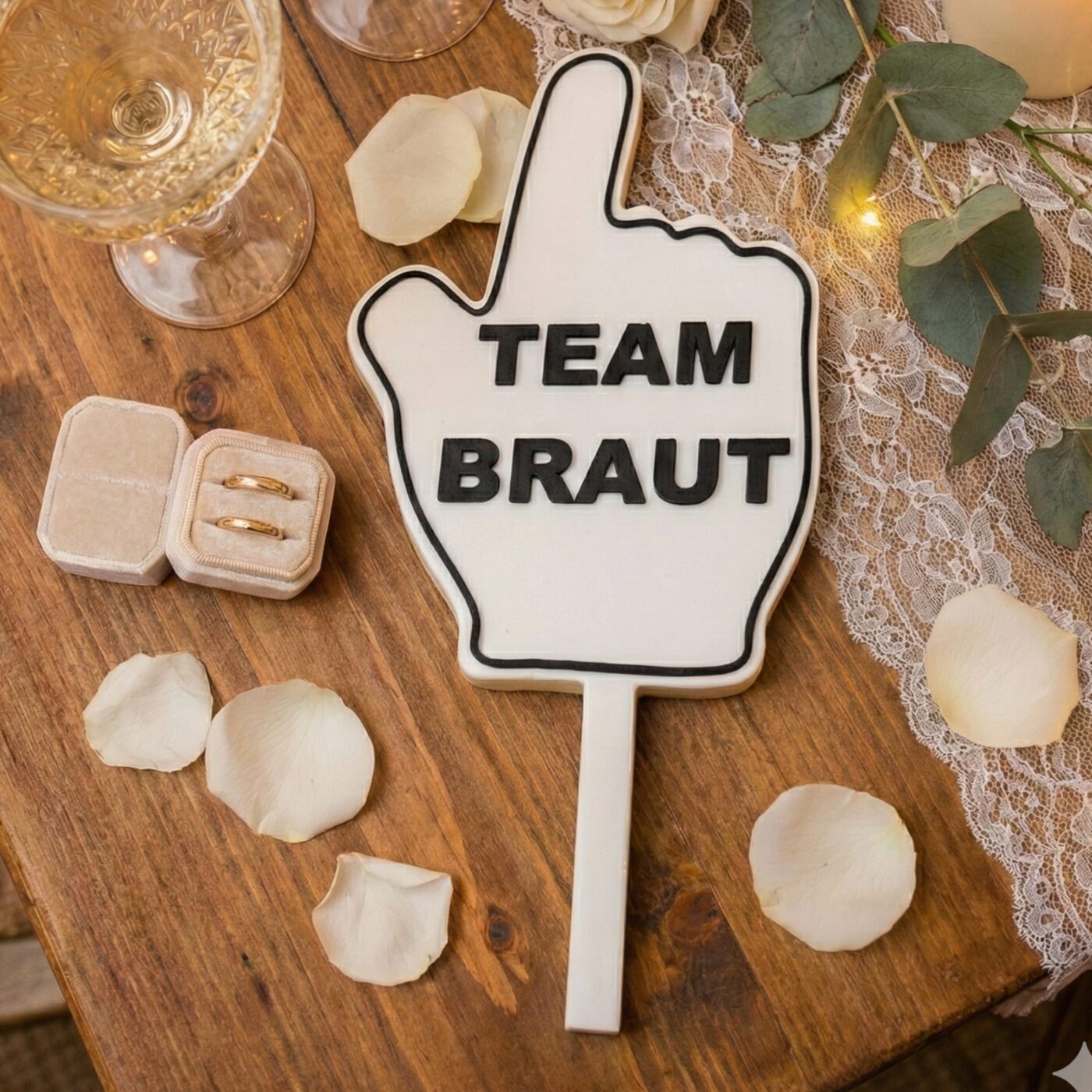 Handgehaltenes Team Braut Schild als Fotobox Props Hochzeit Zubehör neben goldenen Eheringen