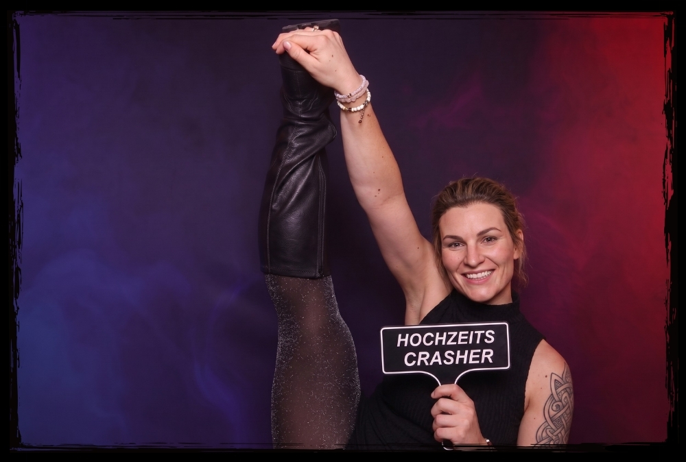 Kreative Fotobox Schilder für Hochzeiten Frau mit Hochzeits-Crasher Schild posiert bei einer Fotobox Aktion