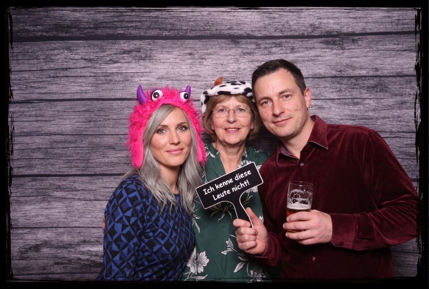 Fotobox Requisiten Schild Ich kenne diese Leute nicht Gruppe mit Monster-Mütze und Kuh-Hut hält Fotobox Schild Ich kenne diese Leute nicht