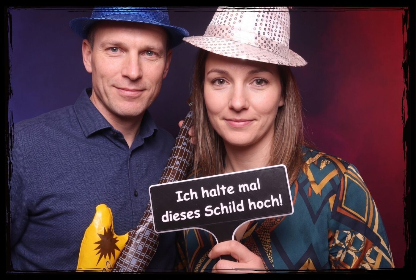 Fotobox Requisiten Schild Ich halte mal dieses Schild hoch Paar mit Partyhut und Gitarre hält ein lustiges Fotobox Schild bereit