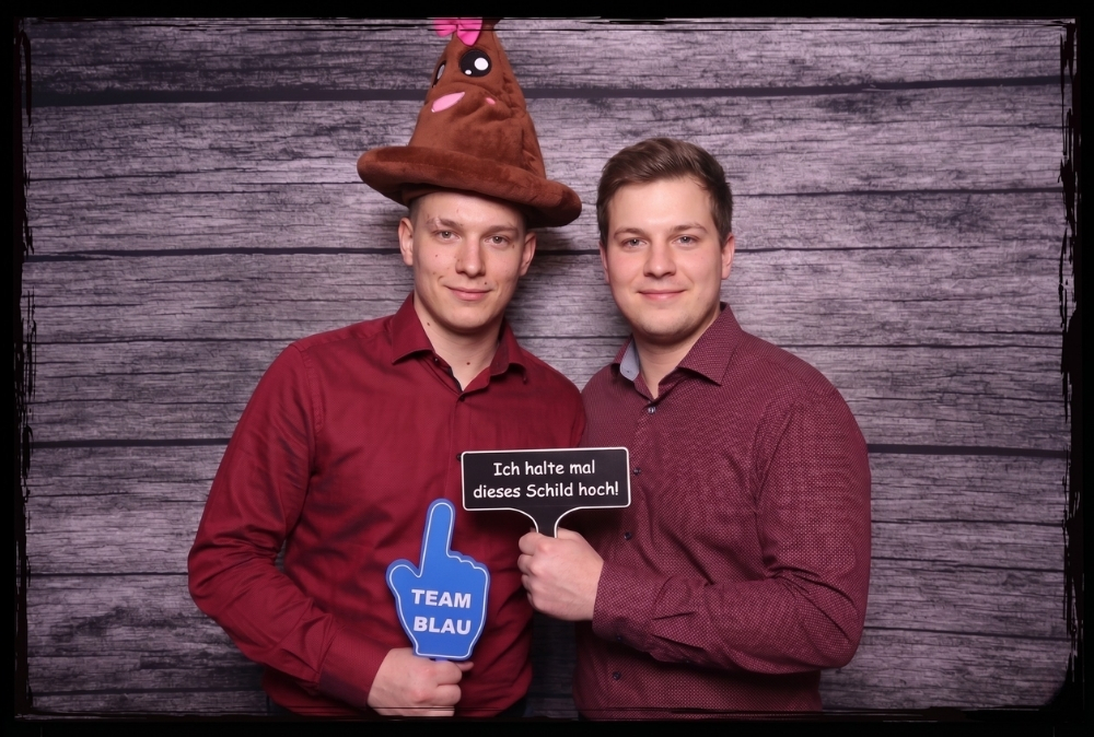 Zwei Männer nutzen 3D-gedruckte Fotobox Schilder mit lustigen Aufschriften