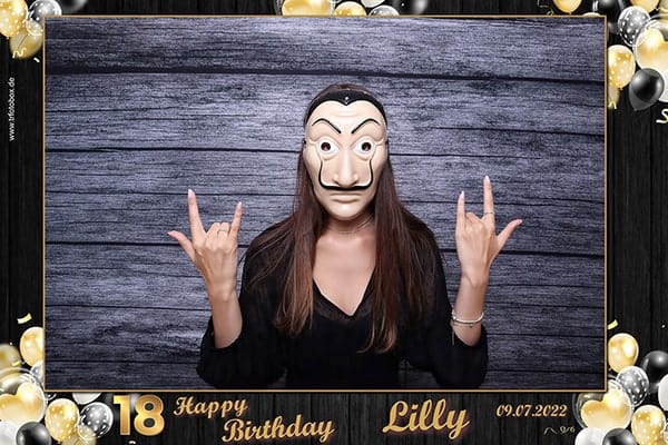 Set aus sechs schwarzen Fotobox Schildern mit lustigen Sprüchen für den 18. Geburtstag auf einem Tisch mit Konfetti