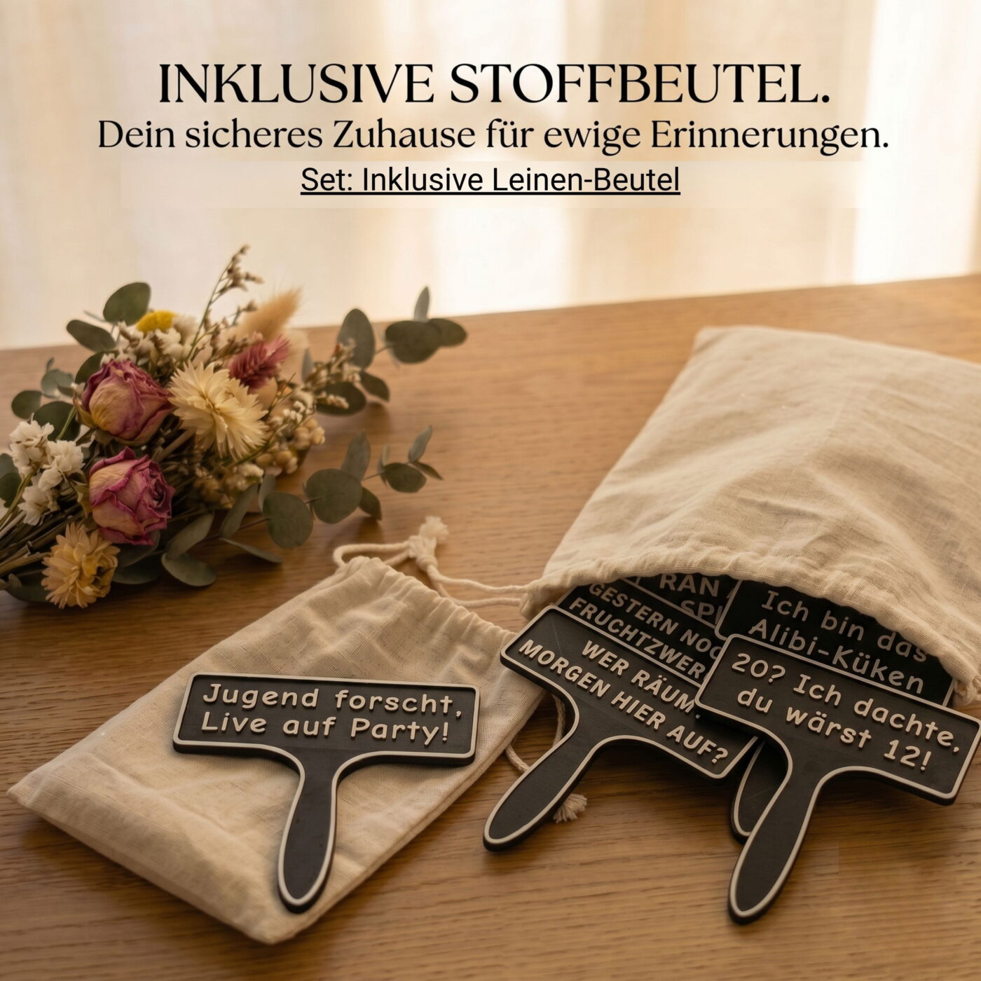 Mehrere schwarze Spruchschilder ragen aus einem beigen Stoffbeutel auf einem Holztisch heraus