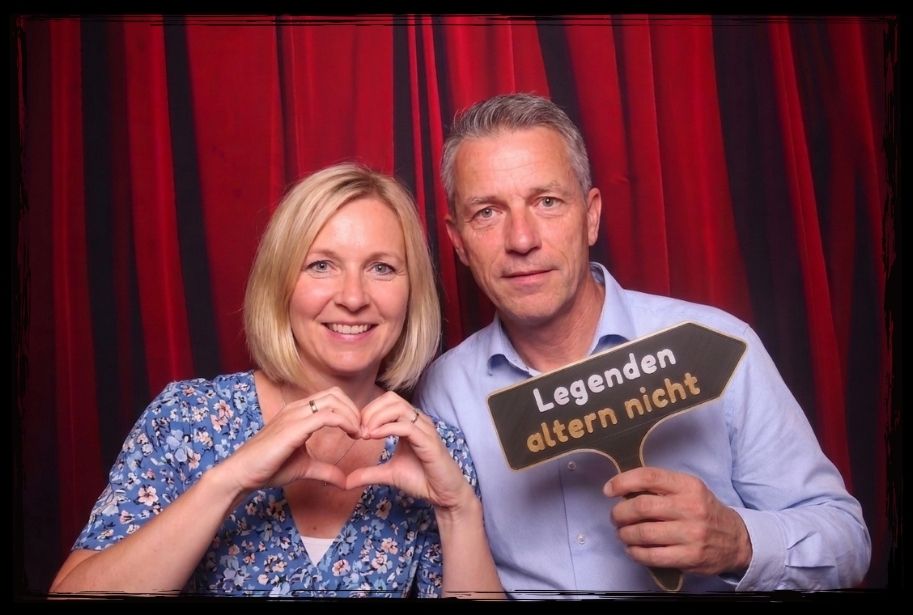 Paar nutzt humorvolle Photo Booth Requisiten auf einer Feier zum 40. Geburtstag