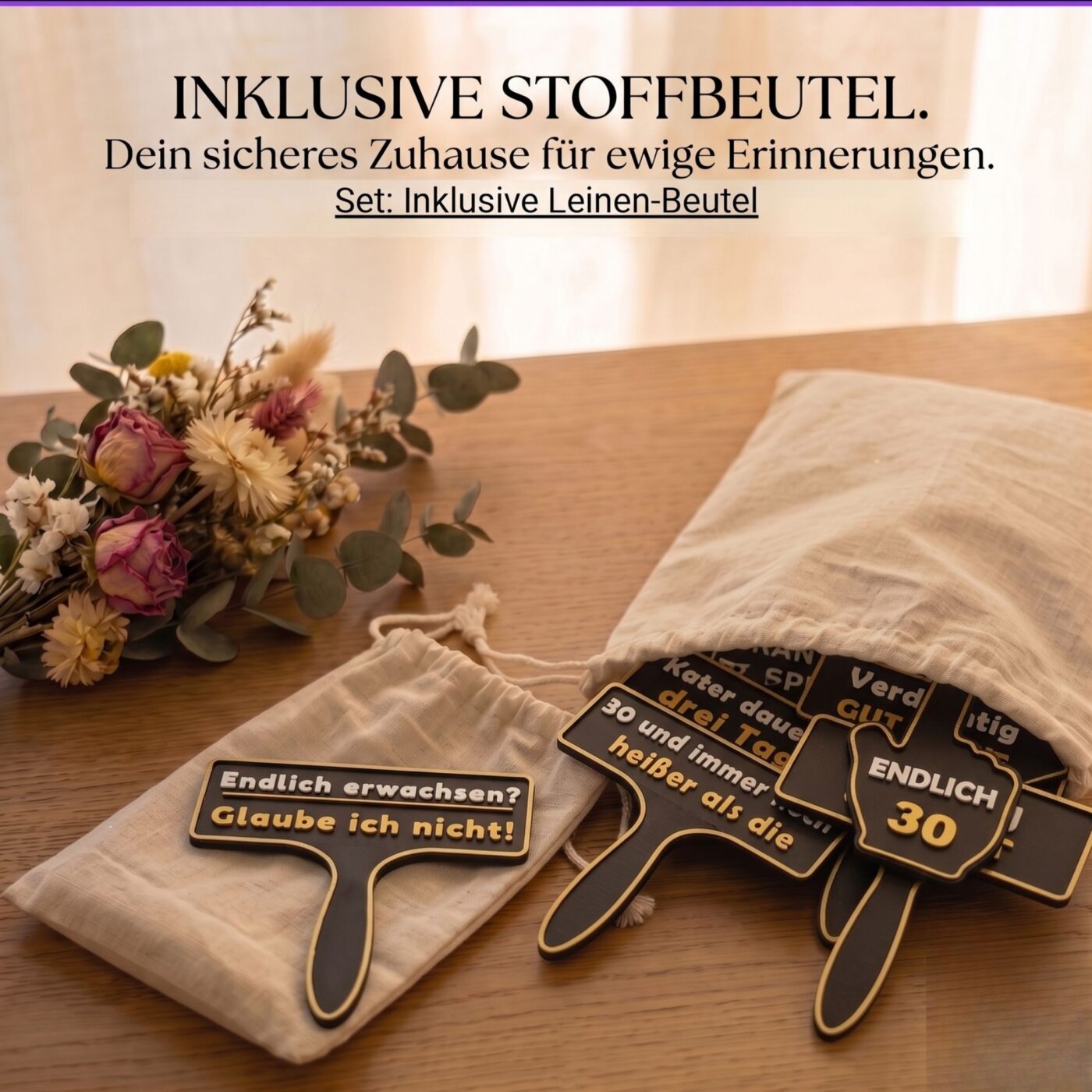 Fotobox Schilder werden auf einem Holztisch in einen hellen Leinenbeutel gepackt