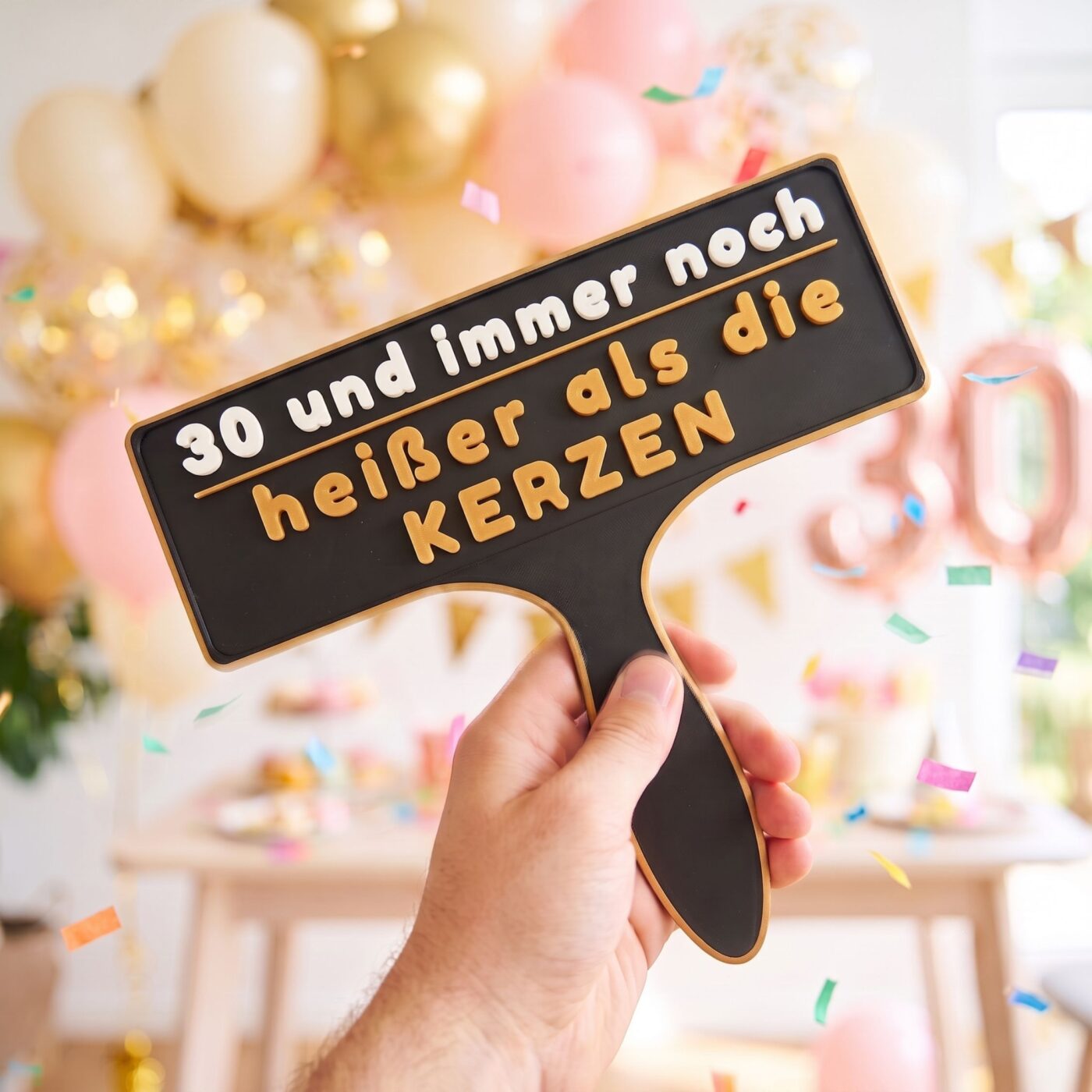 Hand praesentiert das Fotobox Schild 30 und immer noch heisser als die Kerzen auf der Party